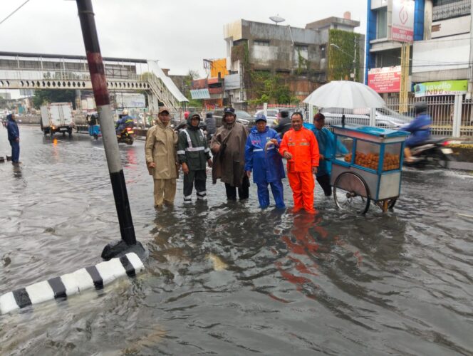 
					Bhabinkamtibmas dan Tim Gabungan Tangani Genangan di Jalan KH Hasyim Ashari Cideng