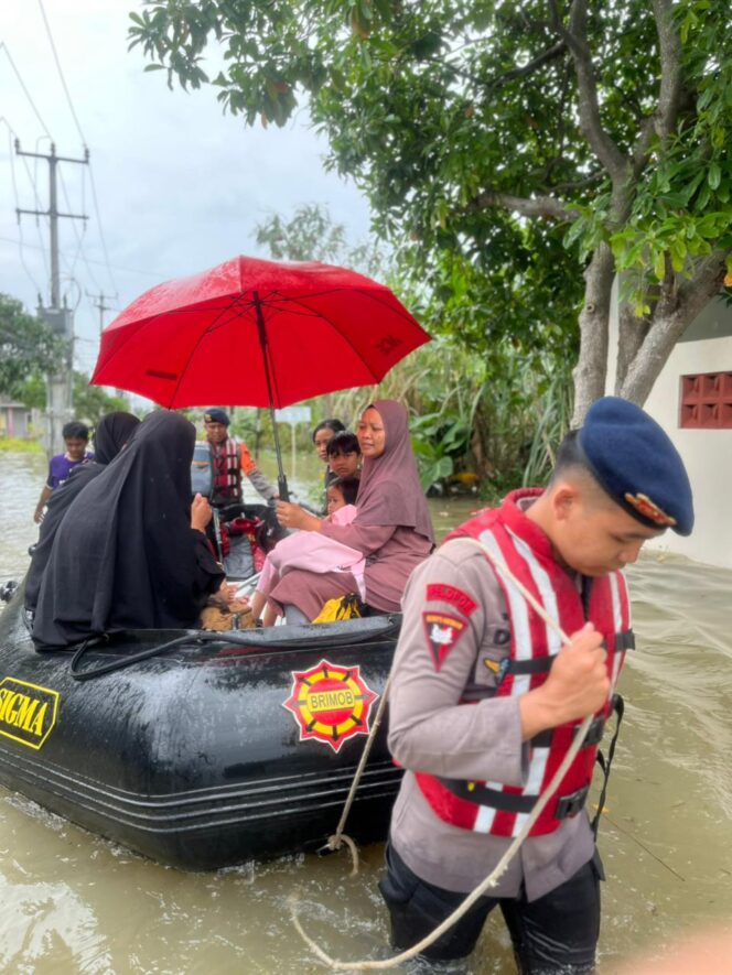 
					Emak-emak Hingga Nakes Naik Perahu Karet Brimob Sebrangi Banjir