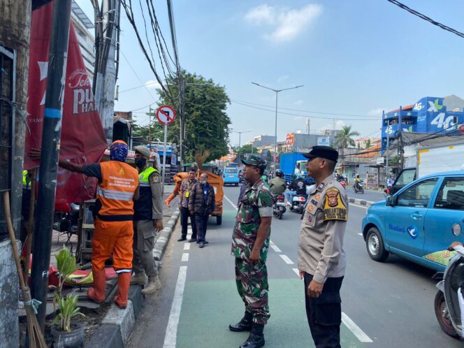 
					Bhabinkamtibmas Kebon Melati Bersama Tiga Pilar Laksanakan Pembersihan Spanduk dan Umbul-Umbul