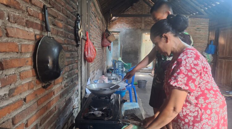 Anggota Satgas TMMD 128 Tak Canggung Bantu Ibu-Ibu Masak Di Dapur