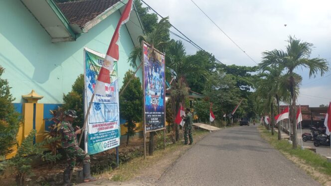 
					Persiapan Penutupan TMMD Reguler ke-128, Sertu Nursanto Pasang Umbul-Umbul di Lokasi Kegiatan
