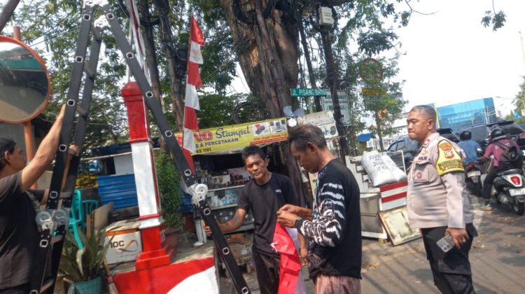 Sambut HUT ke-81 RI, Bhabinkamtibmas Mangga Dua Selatan Bantu Warga Pasang Bendera Merah Putih