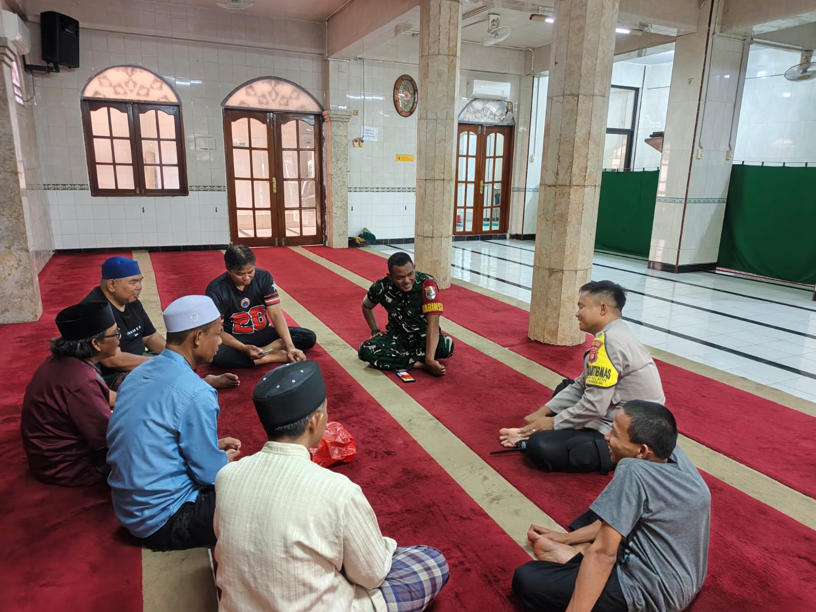 Bhabinkamtibmas dan Babinsa Petojo Selatan Serahkan Bantuan Sarung dalam Giat Cooling System di Masjid Nurul Amal