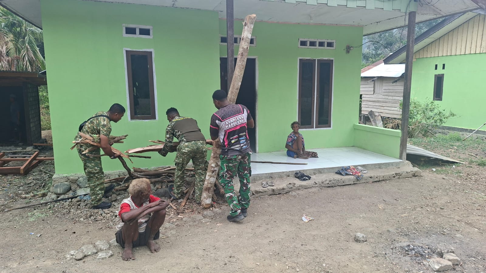 Sentuhan Kepedulian Satgas TMMD Ke-130, Prajurit Bantu Lansia Seabad Angkut Kayu Bakar